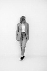 Moderne Businessporträtfotografie in Schwarz-Weiß - photoart hübner business Businessfrau in casual Businesslook vor weißem Hintergrund.