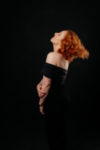 Businessfotografie Portrait mit rotem Haar und schwarzem Outfit - photoart hübner business Porträt einer Frau mit roten Haaren, die elegant und selbstbewusst wirkt, ideal für Business- und Pe.