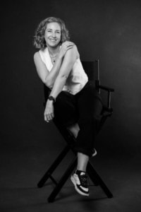Porträt einer jungen Frau in Businesskleidung, lächelnd, sitzend auf einem Stuhl, Schwarz-Weiß-Fotografie. - photoart hübner business Porträt einer lächelnden Frau in Businesskleidung, sitzend auf einem Stuhl, Schwarz-Weiß-Businessfot.