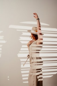 Businessporträt mit Schatteneffekt - photoart hübner business Frau in Businesskleidung mit Hut, Schattenmuster an der Wand.