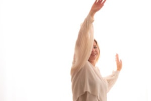 Selbstbewusste Frau posiert professionell - photoart hübner business Frau in hellen Blusen hebt die Arme und zeigt Selbstvertrauen für Business- und Karrierefotos.